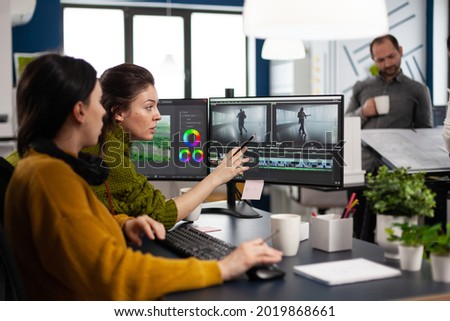 Team of editors women working with modern studio post production software in digital multimedia company. Video maker employees editing film montage in creative agency looking at computer