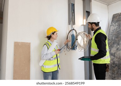 team electrical engineers or technicians is professionally inspecting the wiring and systems in the building. Check electrical equipment to meet safety standards. Use a tablet to check buildings.