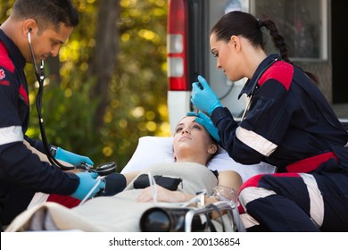 Team Of Emergency Medical Technicians Checking Patients Vital Signs