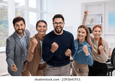 Team of employees celebrating success in office - Powered by Shutterstock