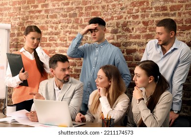 Team Of Employees Working Together On Difficult Task In Office