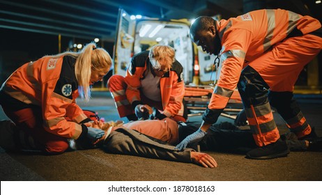 Team Of EMS Paramedics Bring A Stretcher From Ambulance Vehicle And Help An Injured Young Person. Emergency Care Assistants Arrived On The Scene Of A Traffic Accident On A Street At Night. Blur