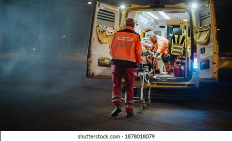 El equipo de paramédicos de EMS reacciona rápido para brindar ayuda médica a pacientes heridos y trasladarlo en ambulancia en una camilla. Asistentes de atención de emergencia llegaron a la escena de un accidente de tránsito en una calle. Desenfoque