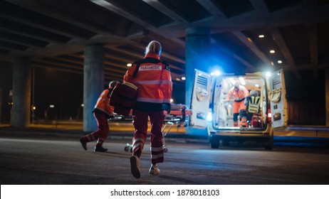Team of EMS Paramedics React Quick to Provide Medical Help to Injured Patient and Get Him in Ambulance on a Stretcher. Emergency Care Assistants Arrived on the Scene of a Traffic Accident on a Street.Blur