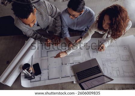 A team engaged in a collaborative discussion about architectural blueprints within a contemporary workspace