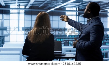 Team of engineers in data center doing brainstorming and running error checking utilities to fix problems. Teamworking colleagues in server hub looking for network issues affecting rigs, camera A