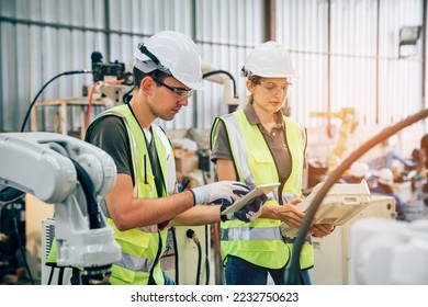 Team of engineers or worker is controlling robot arm machine welding steel, worker using forcing welding with a control screen which is used for precision welding control. - Shutterstock ID 2232750623
