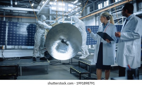 Team of Engineers Working on Satellite Construction, Use Tablet Computer Talk about Data. Aerospace Spaceship Manufacturing Facility: Team of Scientists Building Spacecraft for Space Exploration