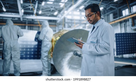 Team Of Engineers Working On Satellite Construction, Scientist Uses Tablet Computer. Aerospace Agency: Diverse Group Of Specialists Developing Spacecraft For Space Exploration Mission