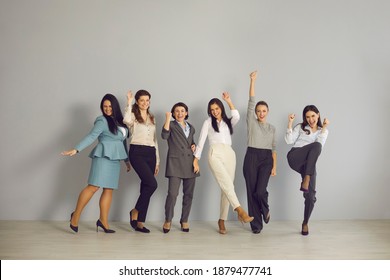 Team Of Excited Young Businesswomen Celebrating Their Success. Group Portrait Of Happy Women Cheering, Smiling And Looking At Camera, Standing Together In Business Office Or Studio