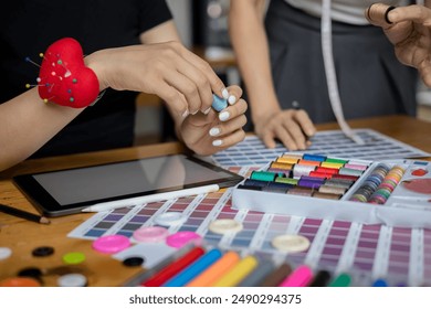 Team fashion designer Working on tablet and color swatch chart at studio - Powered by Shutterstock