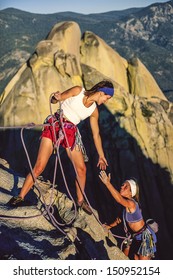 Team Of Female Climbers Conquer The Summit Of A Challenging Rock Spire.