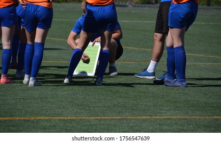 Team of female football players and the coaches going through the strategy for a match. - Powered by Shutterstock