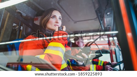 Team of fire fighters driving to an operation using radio