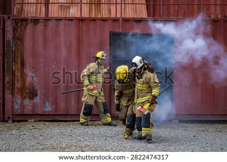 Team of firefighter in fireproof clothe are escaping the burning building with injured buddy for fire extinguish risk rescue mission and accident management