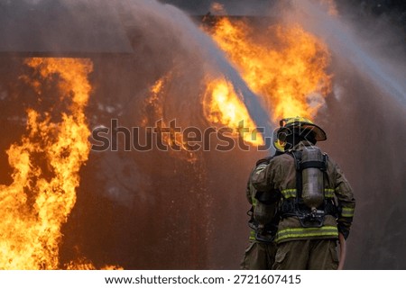 Team of firefighter in fireproof clothe using twirl fog watering hose to put out the burning crashing plane with high flame for fire extinguish risk rescue mission and accident