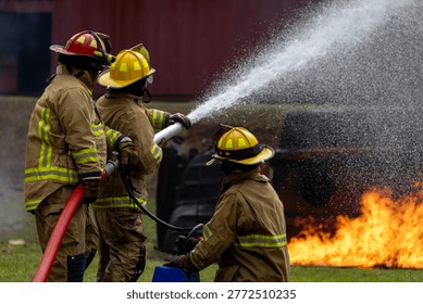 Equipo de bombero con ropa ignífuga usando una manguera de riego de niebla para apagar el avión en llamas con alta llama para extinguir el riesgo de incendio Misión de rescate y accidente