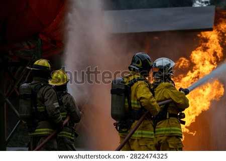 Team of firefighter in fireproof clothes using fog watering hose to put out the burning crashing plane with high flame for fire extinguish risk rescue mission and accident