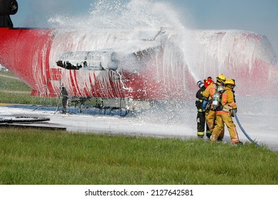team of firefighters spraying foam during aircraft training