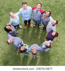 Team forming connected circle basking in sunny field