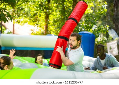 Team Of Friends Playing With Inflatable Sticks On The Trampoline