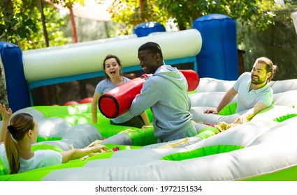 Team Of Friends Playing With Inflatable Sticks On The Trampoline