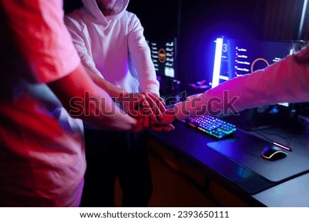 team of gamers hold hands together before game in computer club, teamplay sign