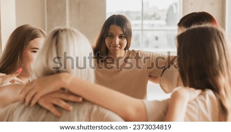 team of girls standing round and hug each other, team spirit and motivation