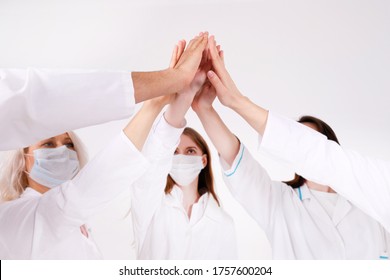 Team Of Group People In Medical Uniform And Face Masks Giving High Five During Corona Virus. Successful Collaboration. 