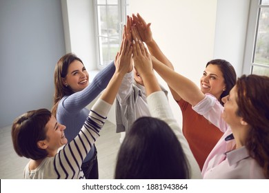 Team of happy confident smiling young women standing in circle and putting hands together, feeling united and empowered. Concept of unity, support, success and reaching common business goal together - Shutterstock ID 1881943864