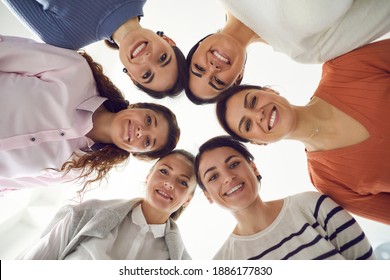 Team Of Happy Different Charming Attractive Young Women Standing Together In Circle And Smiling At Camera. Group Portrait Of Female Friends, Business Partners Or Colleagues. From Below, Low Angle