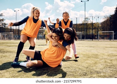 Team Of Happy Female Players Celebrating Winning A Soccer Match On The Field.