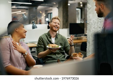 Team of happy freelancers having fun while communicating on lunch break in the office. Focus is on redhead man.  - Powered by Shutterstock