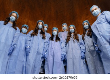 A team of healthcare professionals wearing protective gear, including masks and gloves, gathered in a clinical setting, focused and prepared for their tasks.