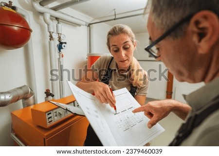 Team of heating engineers checks a old gas heating system with a paper instruction at a boiler room in a house. Gas heater replacement obligation concept image