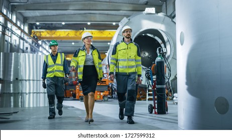 Team Of Heavy Industry Engineers And Workers Walking Through Pipe Manufacturing Factory. Modern Facility For Design And Construction Of Oil, Gas And Fuels Transport Pipeline.