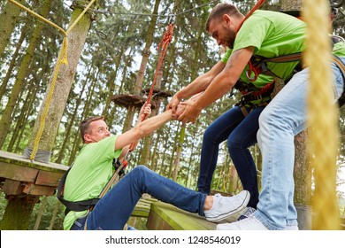 Team Helps Man Climb The High Ropes Course During A Team Building Event