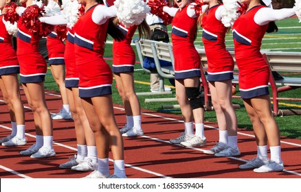 A Team Of High School Cheerleaders Performing A Cheer During  A Schools Homecoming Football Game.