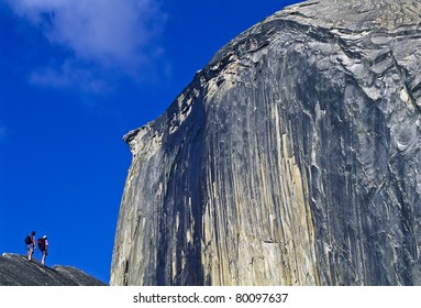 Team Of Hikers Approach Half Dome In Yosemite National Park.