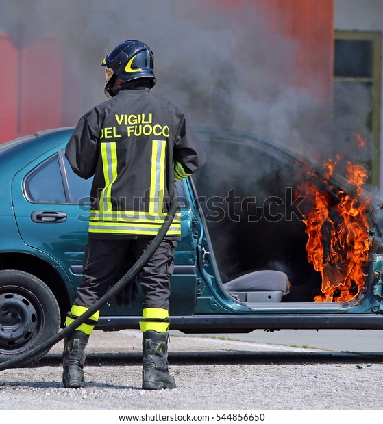 team of Italian firemen extinguished the car\
fire after the car accident with the words in the jacket that means\
FIREMEN in Italian\
language