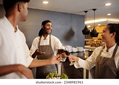 Team of joyful cooks drinking wine when celebrating restaurant opening - Powered by Shutterstock