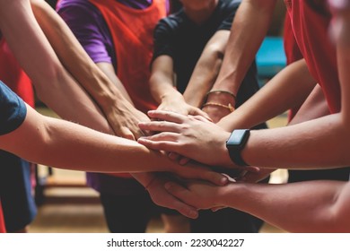 Team of kids children basketball players stacking hands in the court, sports team together holding hands getting ready for the game, playing indoor basketball, team talk with coach, close up of hands - Powered by Shutterstock