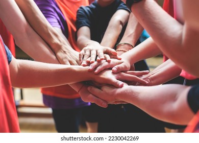 Team of kids children basketball players stacking hands in the court, sports team together holding hands getting ready for the game, playing indoor basketball, team talk with coach, close up of hands - Powered by Shutterstock