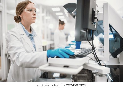 A team of laboratory technicians conduct a series of tests on a chemical analyzer in a biological laboratory. Two female scientists work in a modern equipped computer laboratory - Powered by Shutterstock