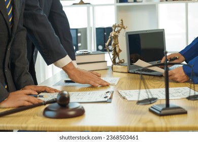 A team of lawyers shares knowledge and discusses difficult cases. from one's conduct Lawyers reviewing court documents. Defendant, defense lawyer and relatives standing in the courtroom. African - Powered by Shutterstock