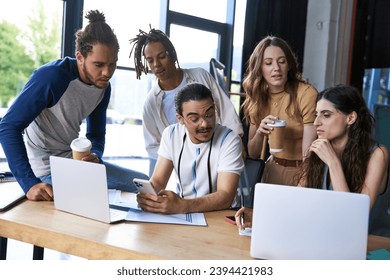 team lead in eyeglasses with smartphone near laptop and multiethnic colleagues with paper cups - Powered by Shutterstock