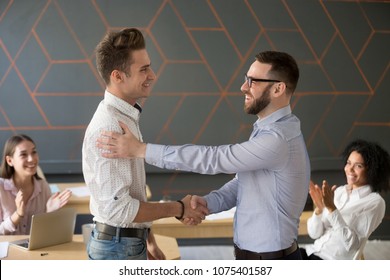 Team leader handshaking employee congratulating with professional achievement or career promotion, thanking for good project result while team supporting applauding, appreciation recognition concept