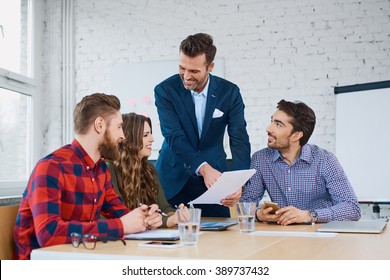 Team leader  talking with coworkers in modern office. Business or education concept
