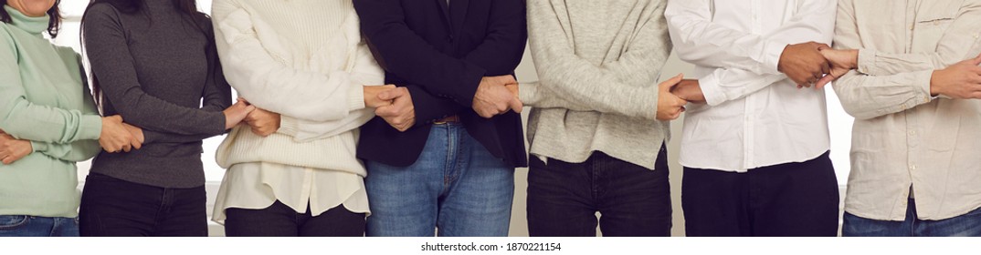 Team Of Loyal Mixed Race Company Employees Standing Together And Holding Hands. Midsection Faceless Unrecognizable Business People For Web Banner. Unity, Teamwork, Support And Strong Community Concept