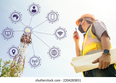 Team male architect engineers wearing masks helmets reporting on radio communications tower structure holds blueprints to monitor telecommunication signals, 5G networks internet data. - Shutterstock ID 2204283851